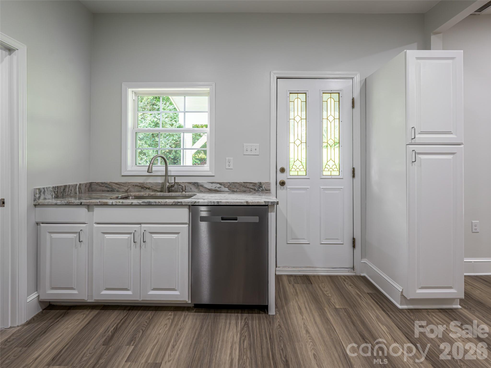 172 Reed Street Canton, NC 28716 - Photo 19 of 48 a kitchen with granite countertop wooden floors and white cabinets