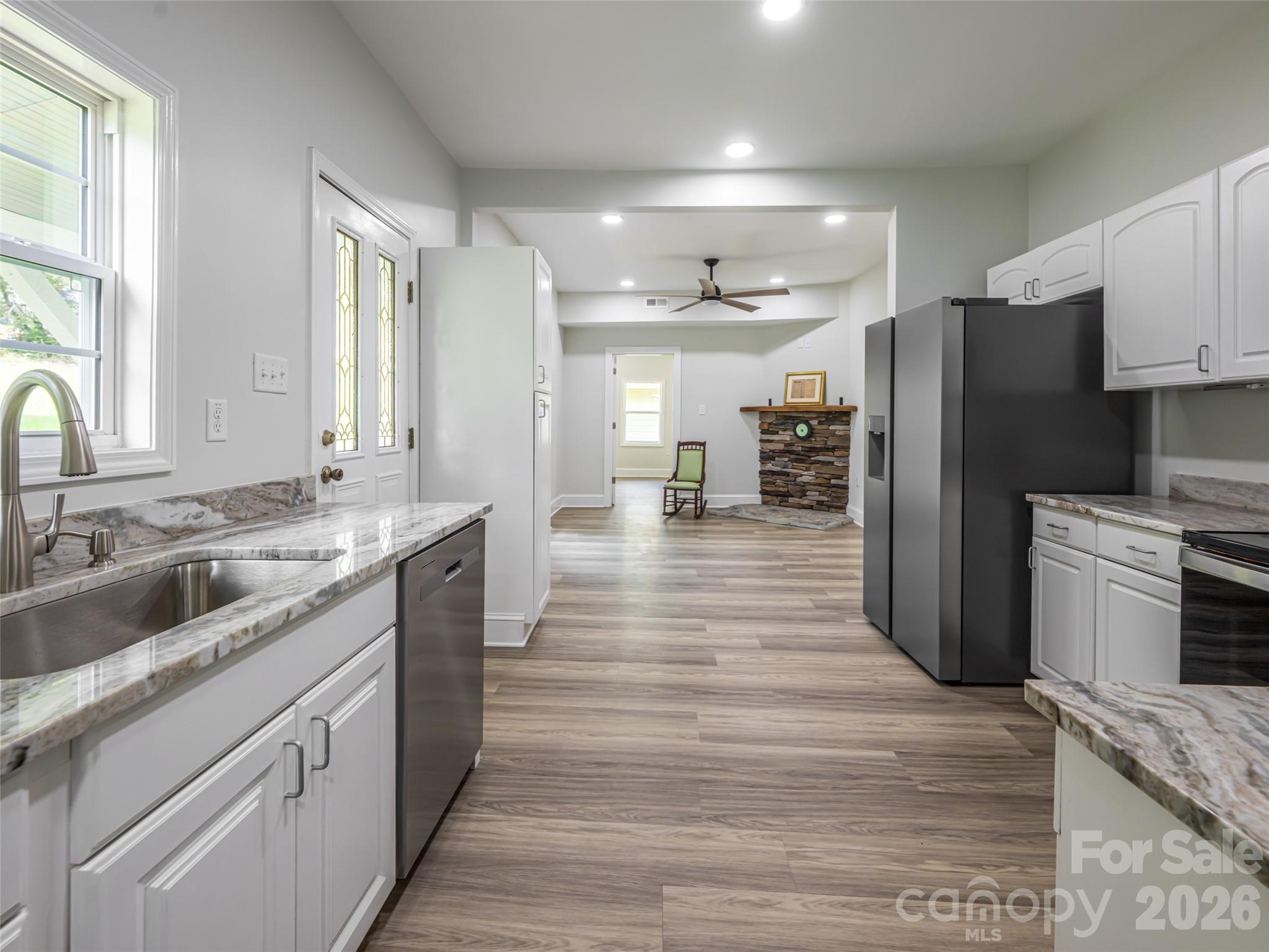 172 Reed Street Canton, NC 28716 - Photo 21 of 48 a large kitchen with a center island wooden floor stainless steel appliances and windows