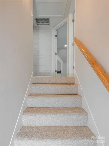 a view of staircase with white walls and a window