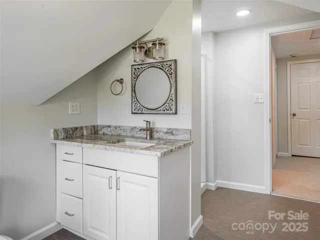 a bathroom with a granite countertop sink and a mirror