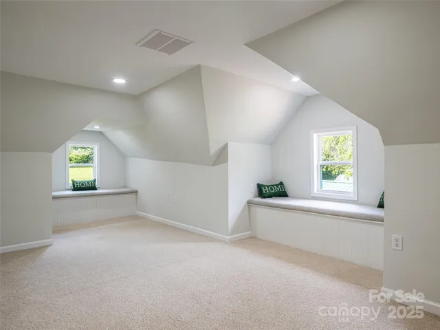 an empty room with windows and bed