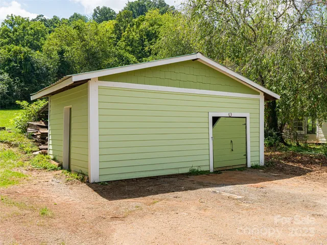 a front view of a house with a garden and trees