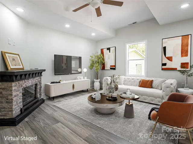 a living room with furniture a flat screen tv and a fireplace