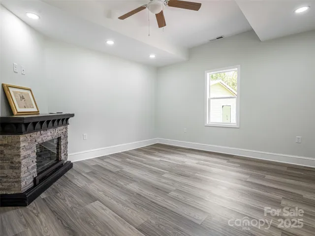 an empty room with windows and fireplace