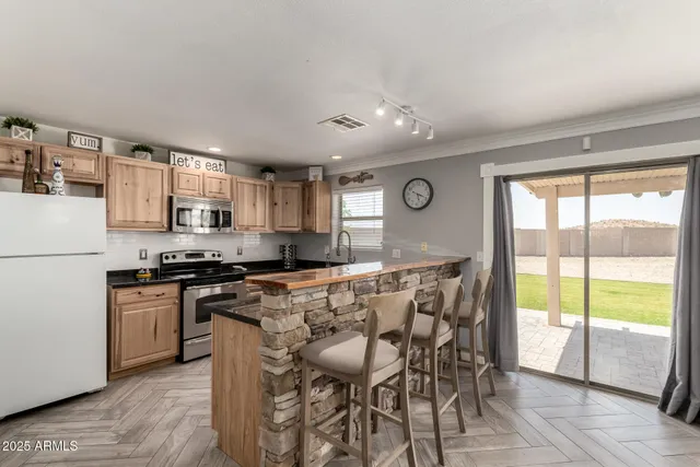 a kitchen with stainless steel appliances granite countertop a stove top oven a sink and a refrigerator