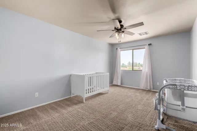 an empty room with windows and fan