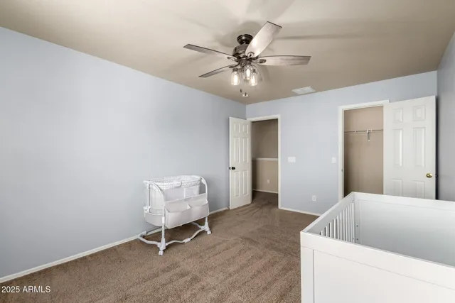 a living room with furniture and a chandelier fan