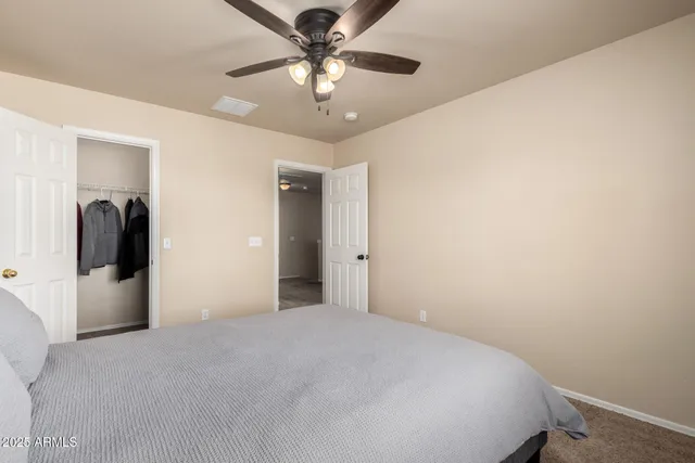 a view of a big room with closet and chandelier fan