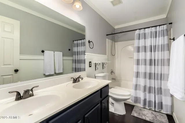 a bathroom with a double vanity sink toilet and shower