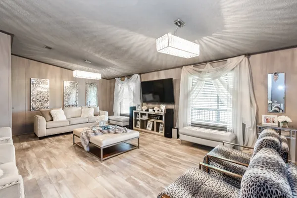 a living room with furniture flat screen tv and a large window