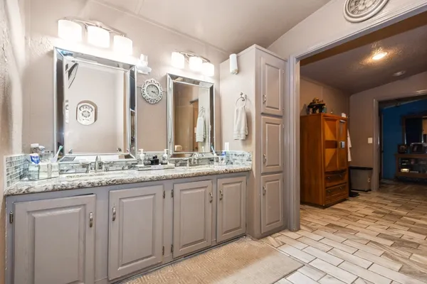 a bathroom with a granite countertop sink and a mirror