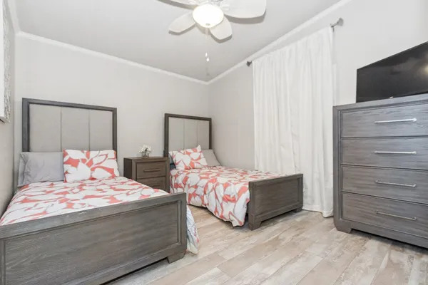 a bedroom with a bed and a flat tv screen on dresser