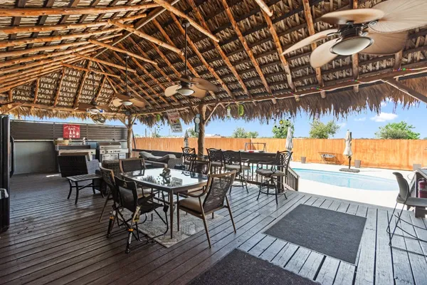 a view of a chairs and table in patio with wooden floor