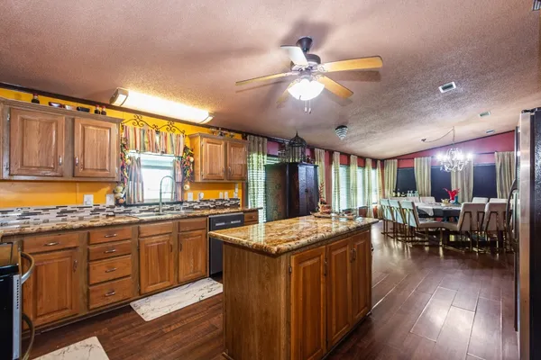 a kitchen with stainless steel appliances granite countertop lots of counter top space and wooden floors