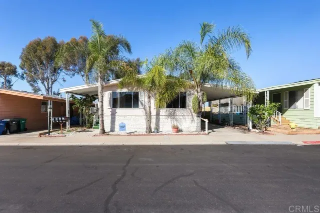 a front view of a building with palm trees
