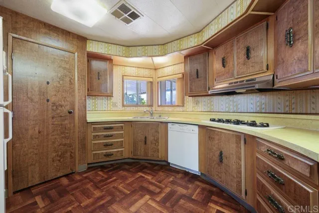 a kitchen with sink cabinets and wooden floor