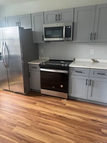 a kitchen with stainless steel appliances granite countertop a stove a microwave and a refrigerator