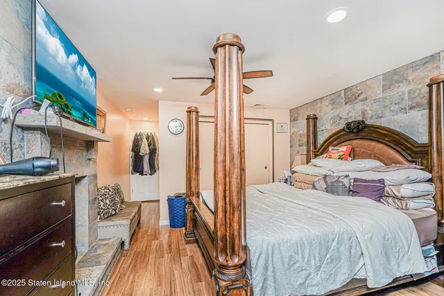 a bedroom with a bed and a flat tv screen on the dresser