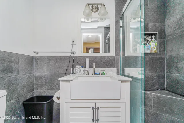 a bathroom with a sink a toilet and shower