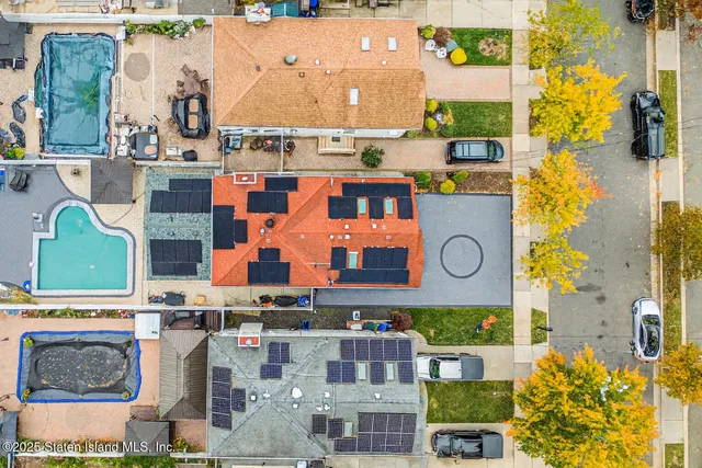 an aerial view of residential houses with outdoor space and parking