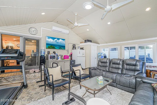 a living room with furniture kitchen view and a large window