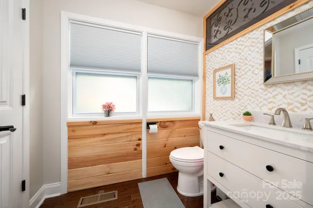 a bathroom with a sink a toilet and a window