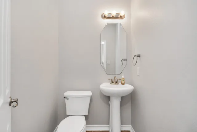 a bathroom with a sink toilet and a mirror