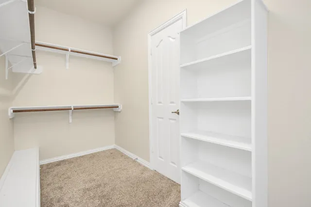 a view of walk in closet with empty racks