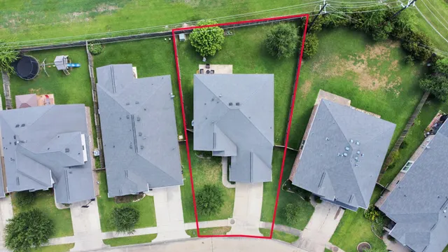 an aerial view of a house with garden space and street view
