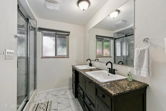a bathroom with a granite countertop sink and a mirror