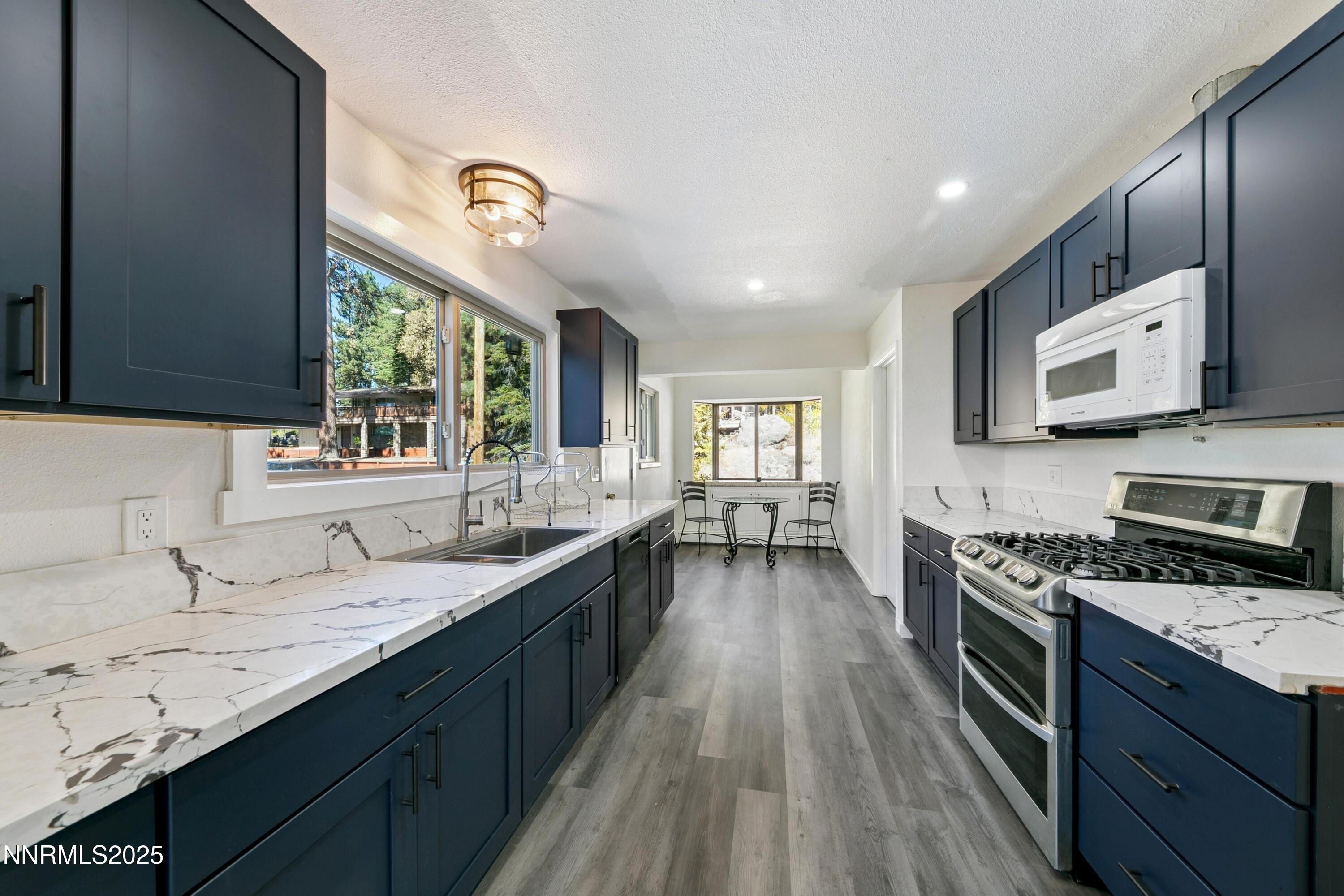 207 Cedar Ridge Drive Zephyr Cove, NV 89448 - Photo 3 of 26 a kitchen with granite countertop stainless steel appliances a sink dishwasher a stove top oven a refrigerator with wooden floors