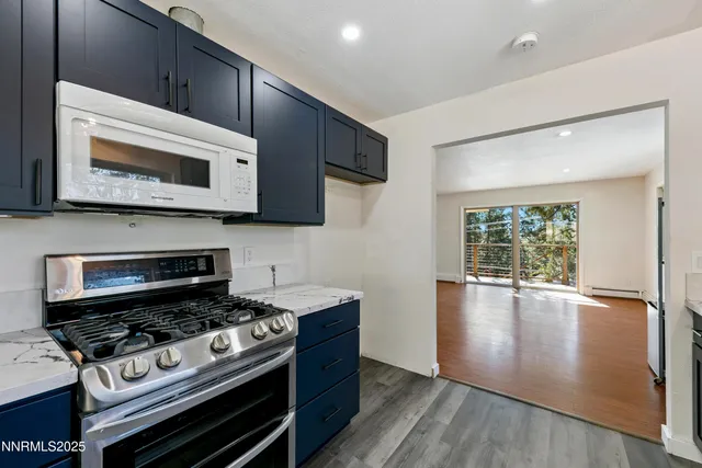 a kitchen with a stove a microwave and window