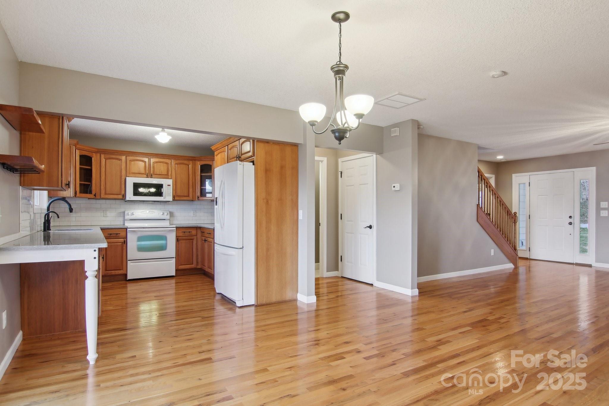 76 Eastern Sky Drive Canton, NC 28716 - Photo 19 of 48 a view of a kitchen center island wooden floor and a chandelier