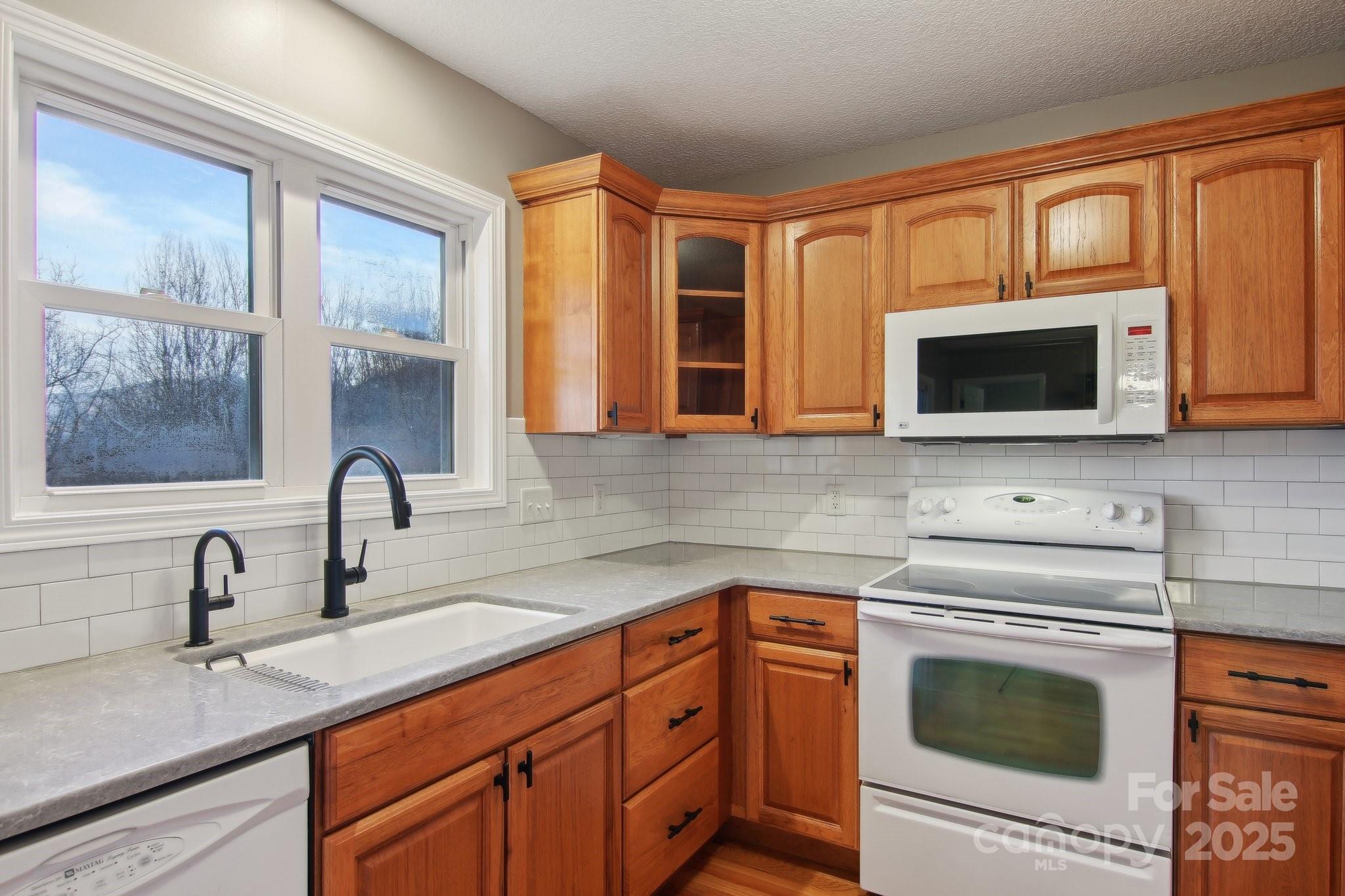 76 Eastern Sky Drive Canton, NC 28716 - Photo 22 of 48 a kitchen with stainless steel appliances granite countertop a sink a stove and microwave