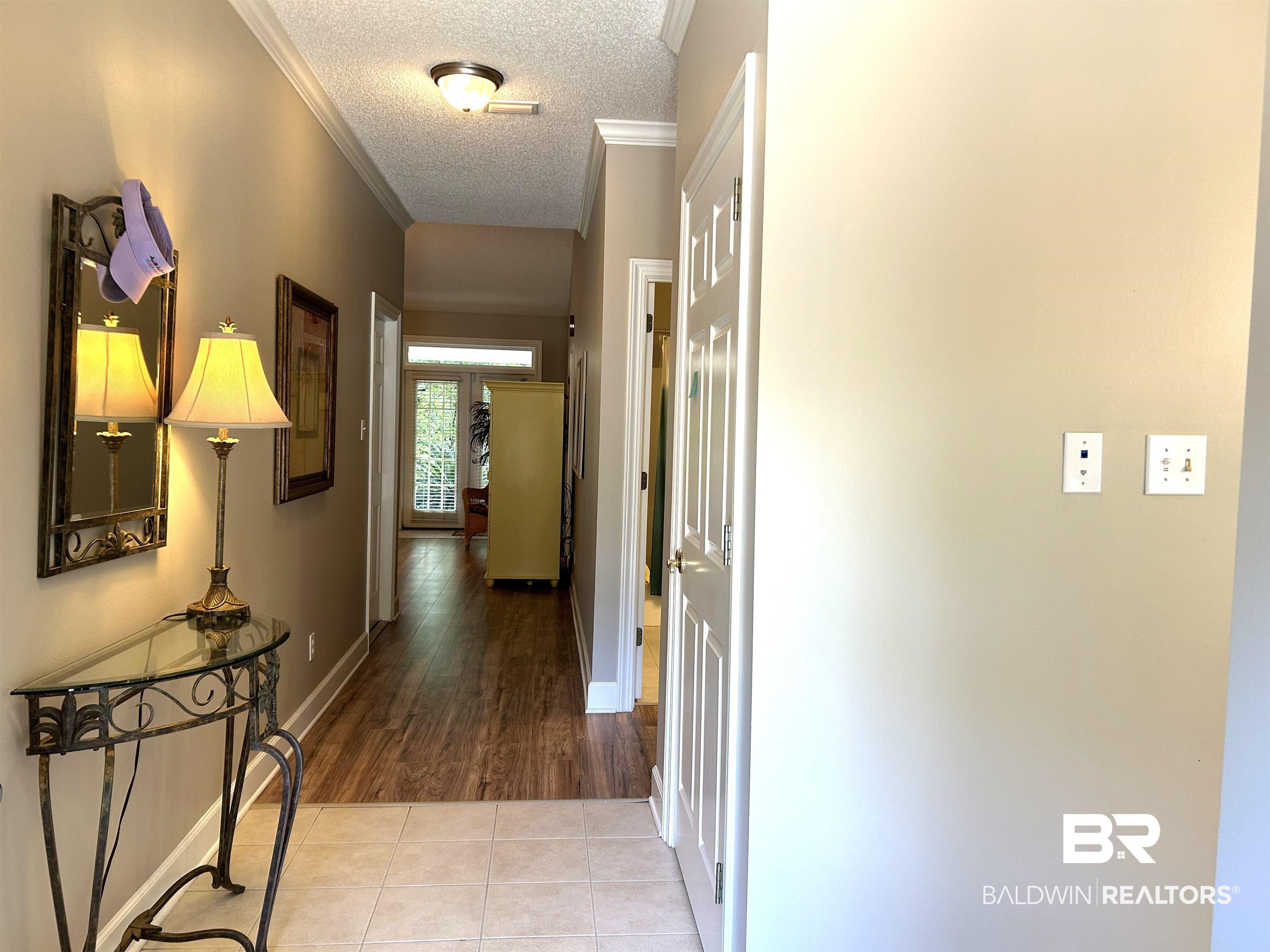 430 West Fort Morgan Road, Unit 404 Gulf Shores, AL 36542 - Photo 4 of 31 Corridor with ornamental molding, a textured ceiling, and tile patterned flooring