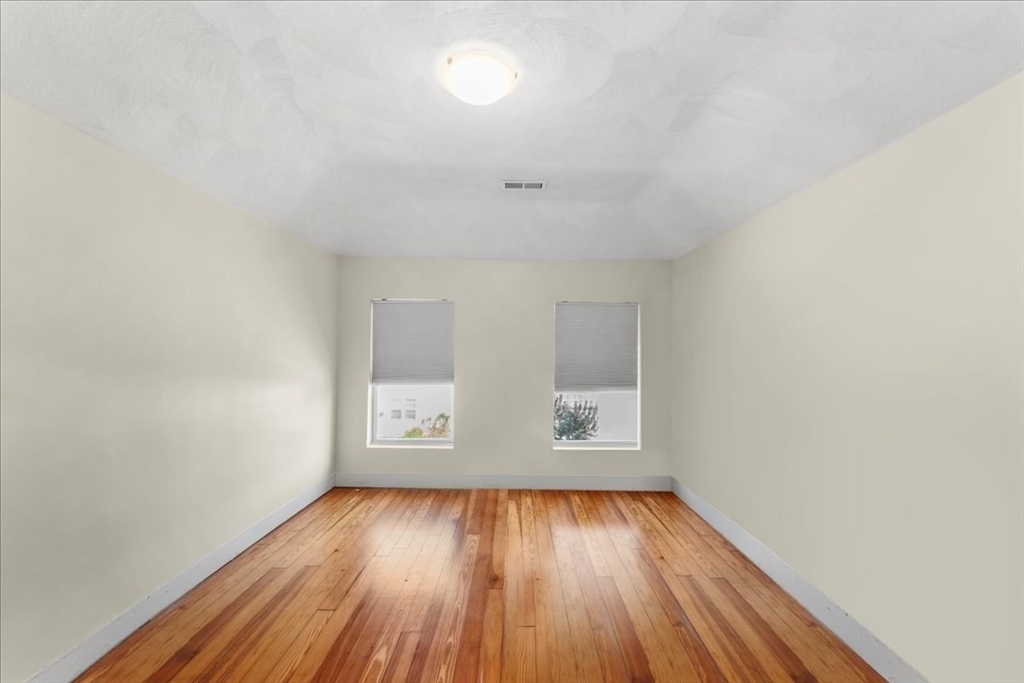 49 A Massasoit Avenue, Unit 2 Hull, MA 02045 - Photo 13 of 19 an empty room with wooden floor and windows