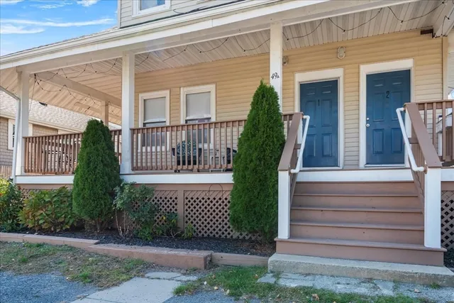 a view of a house with a small yard and wooden floor and fence