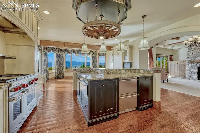 a kitchen with stainless steel appliances granite countertop a stove and a wooden floors