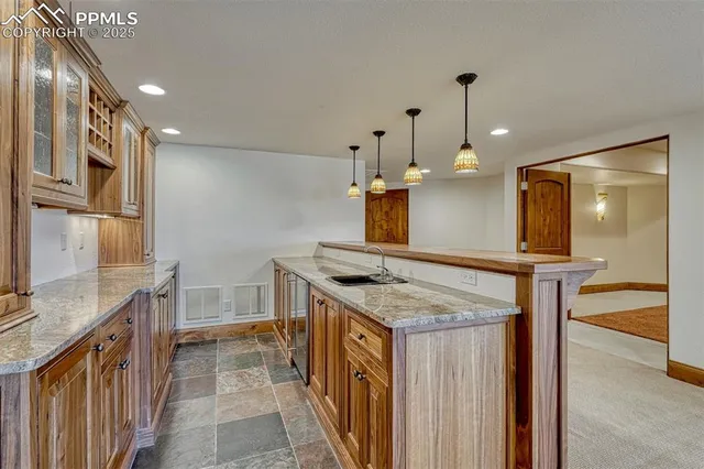 a kitchen with stainless steel appliances granite countertop a sink a stove and a wooden floors