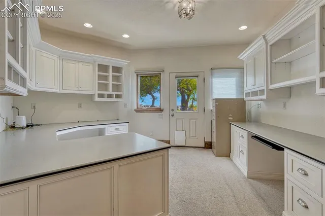 a kitchen with granite countertop a sink a stove and cabinets