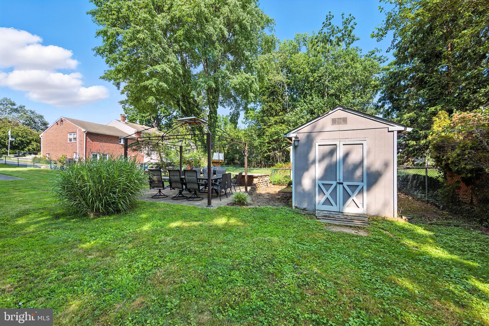 336 Kent Road Springfield, PA 19064 - Photo 9 of 36 a view of a backyard with table and chairs and a fire pit
