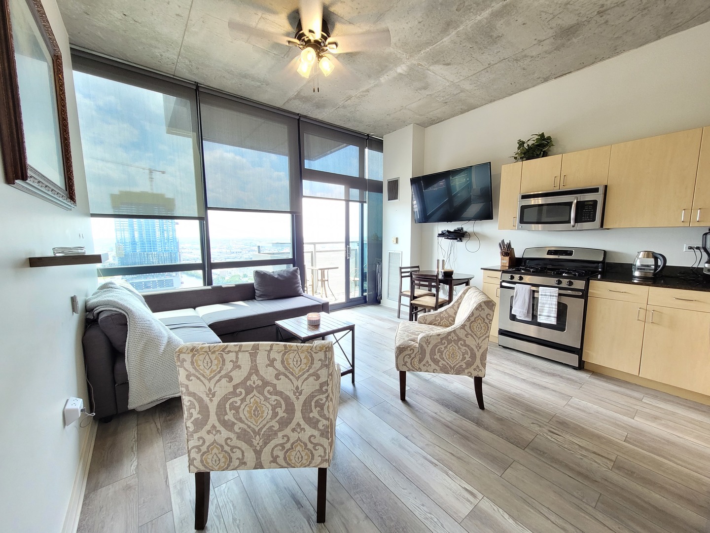 235 West Van Buren Street, Unit 2608 Chicago, IL 60607 - Photo 4 of 20 a living room with stainless steel appliances a kitchen island furniture a flat screen tv and a sink