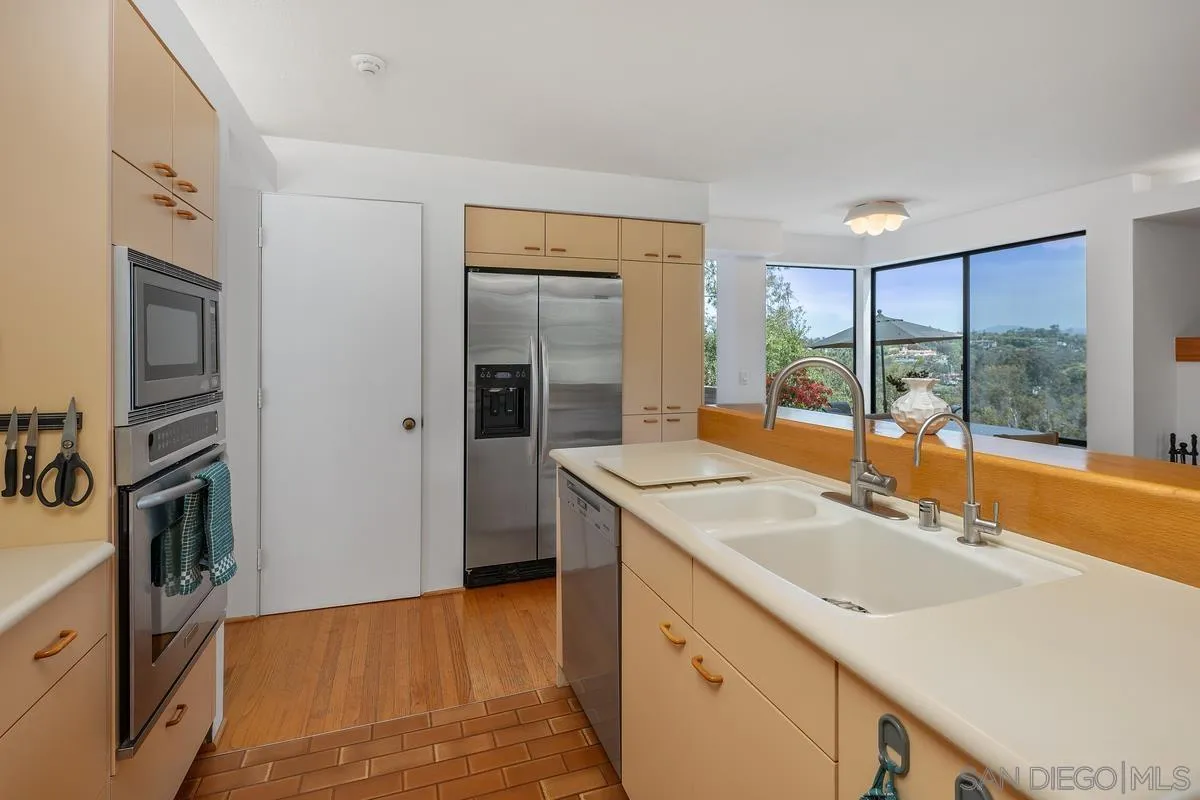 14430 Rancho Santa Fe Farms Road Rancho Santa Fe, CA 92067 - Photo 23 of 51 a kitchen with a sink and refrigerator
