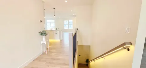 a view of a hallway with wooden floor
