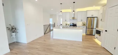 a large kitchen with a refrigerator a sink and a stove