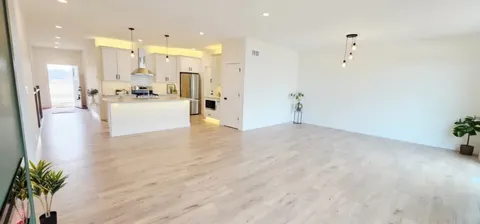 a view of large kitchen with cabinets and wooden floor