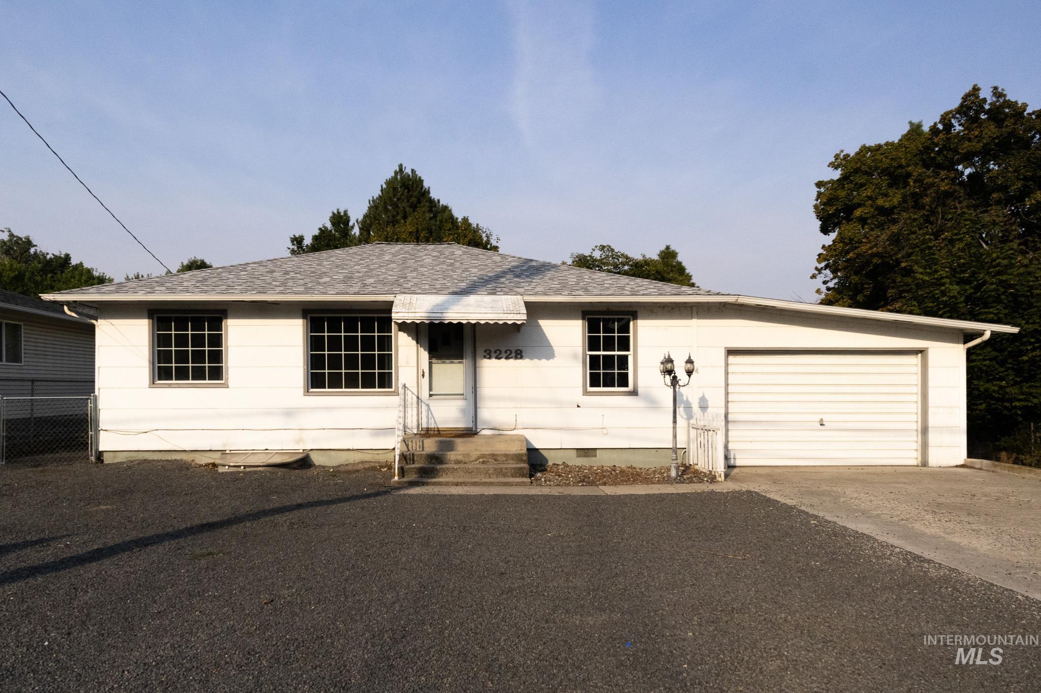 Ranch-style home featuring crawl space, driveway, roof with shingles, and an attached garage