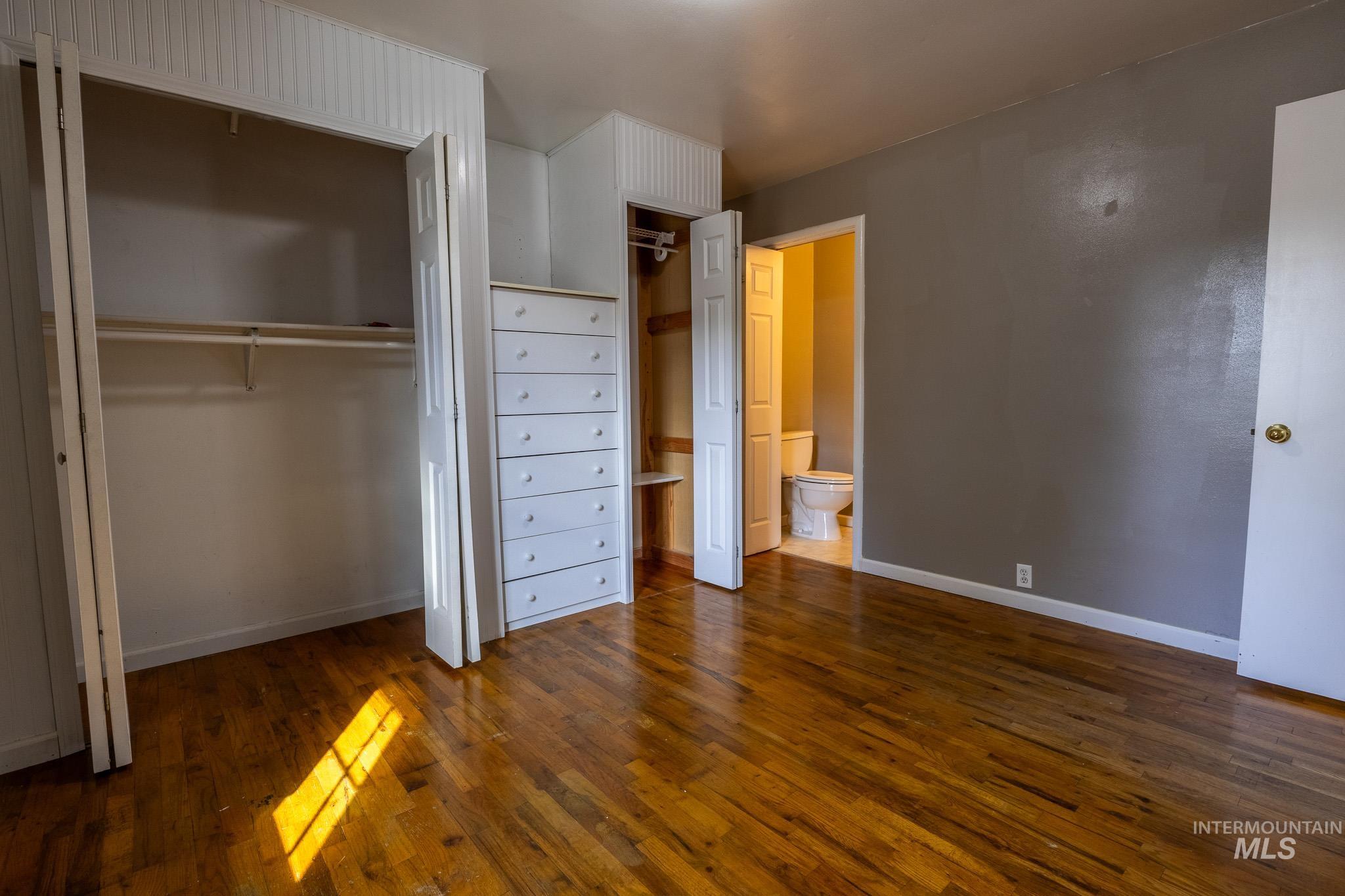 3228 5th Street Lewiston, ID 83501 - Photo 11 of 24 Unfurnished bedroom with two closets, dark wood-type flooring, and ensuite bath