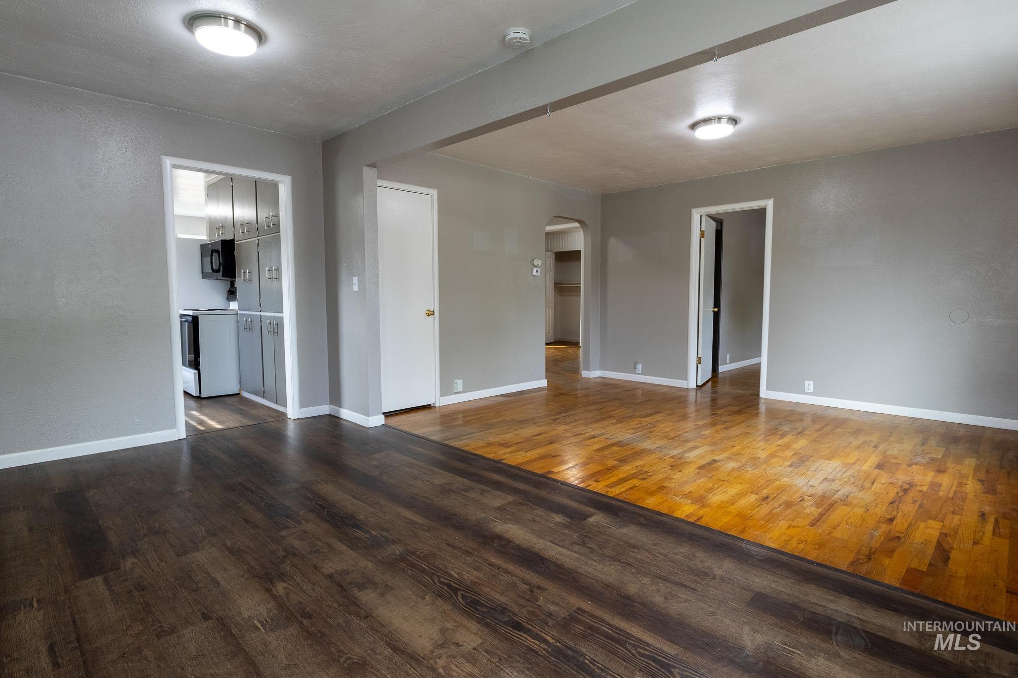 3228 5th Street Lewiston, ID 83501 - Photo 12 of 24 Unfurnished living room with dark wood-type flooring and arched walkways