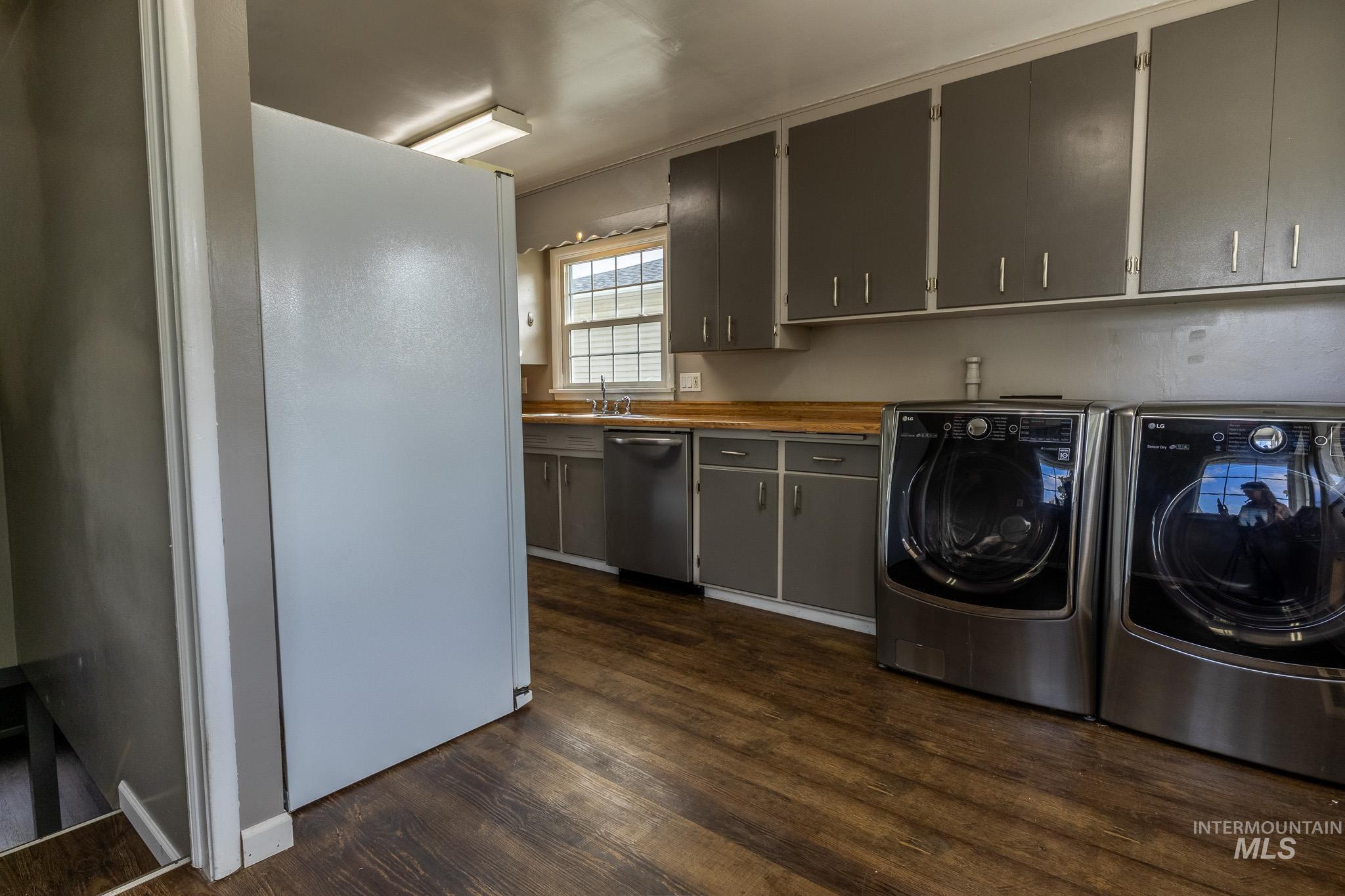 3228 5th Street Lewiston, ID 83501 - Photo 15 of 24 Laundry room featuring washer and dryer, dark wood finished floors, and cabinet space